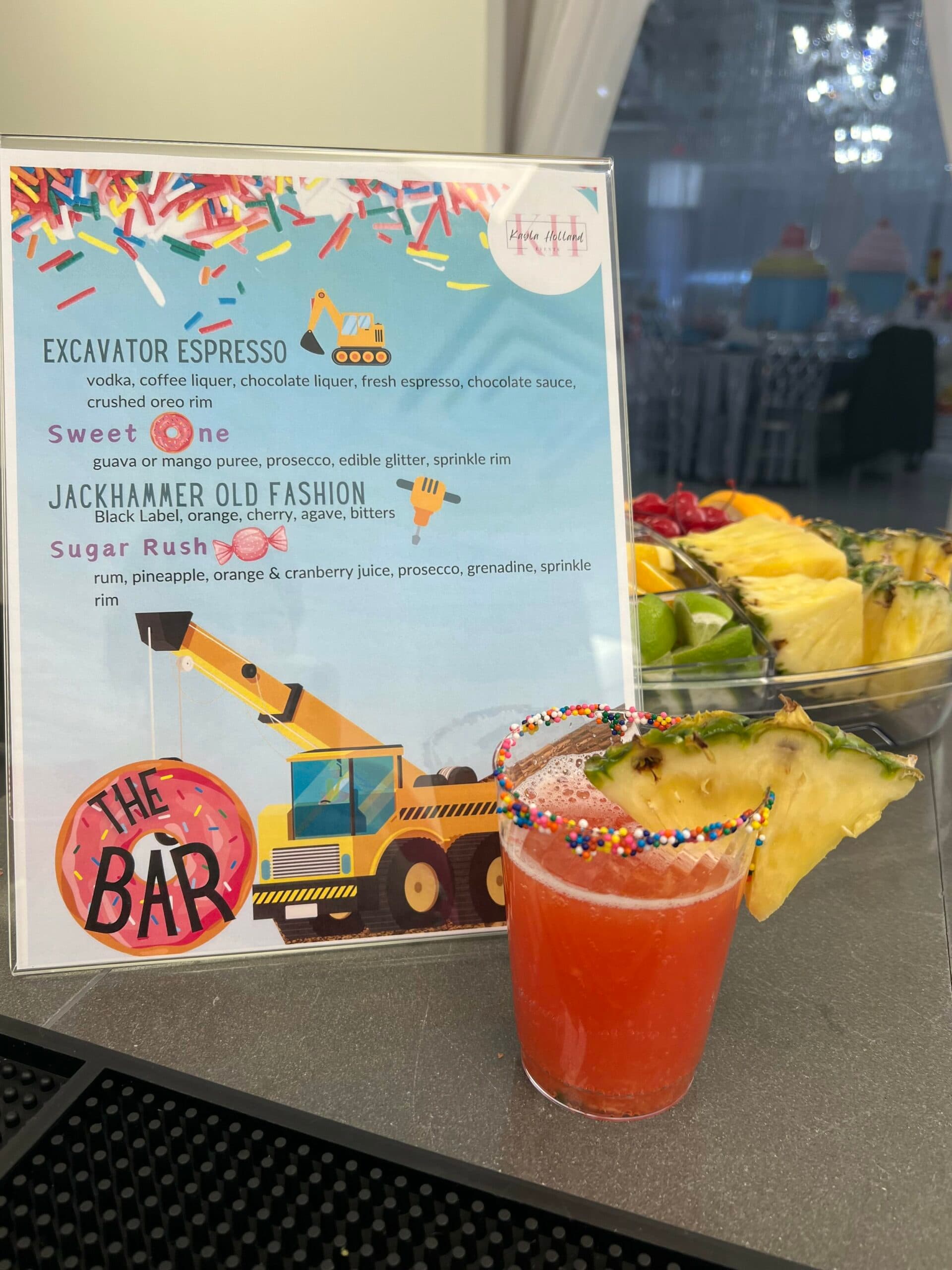 A construction-themed kids' party drink menu next to a pineapple mocktail