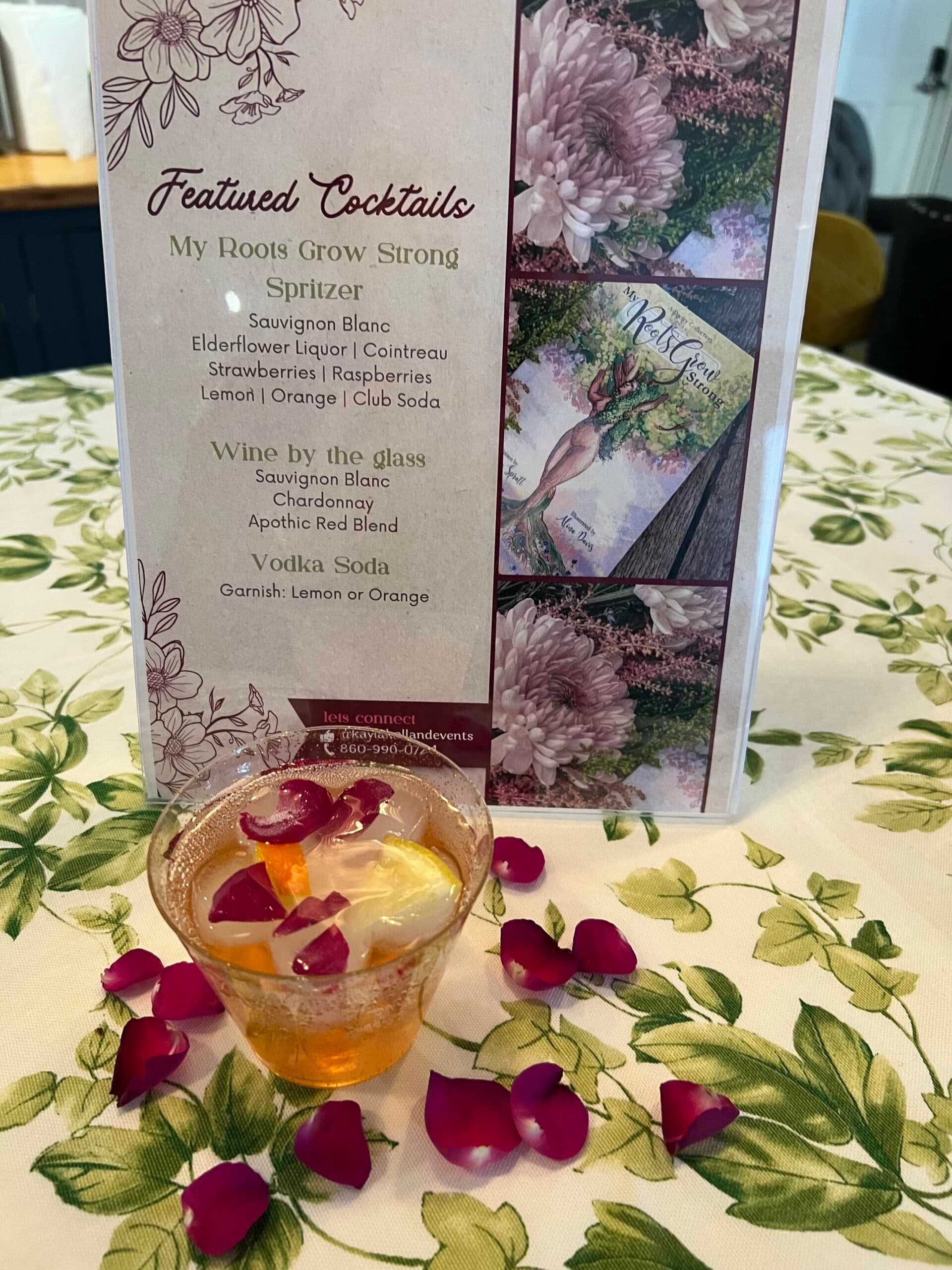 A featured cocktails menu beside a gin cocktail dressed with rose petals