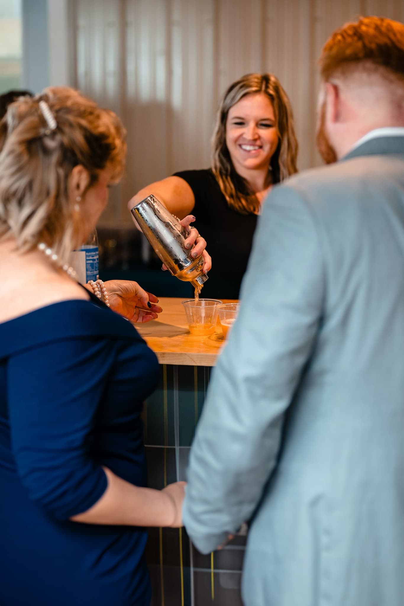 Kayla shaking a cocktail for guests at a wedding bar